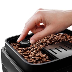 DeLonghi Magnifica Evo Automatic Coffee Maker bean hopper close-up, hand adjusting grind settings dial over fresh coffee beans
