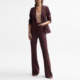 Model wearing Reiss Flora Flared Trousers in pink, mid rise with flared leg, styled with matching blazer and nude top