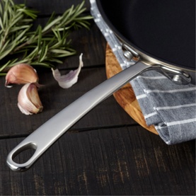 Stellar Eclipse Non-Stick Frying Pan 28cm in stainless steel, handle detail shown styled with garlic