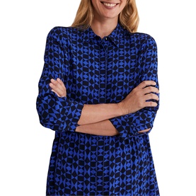 Model wearing Phase Eight Bregitta Geo Print Shirt Dress in black with blue geometric print, bracelet sleeves, and collar, arms crossed
