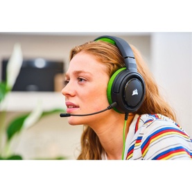 Model with Corsair HS35 Stereo Gaming Headset in green, featuring detachable microphone, worn over ear, styled with striped top