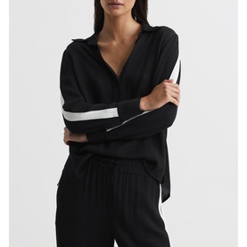 Model wearing Reiss Millie Side Stripe Shirt in blue with contrast white sleeve stripe, paired with matching wide-leg trousers