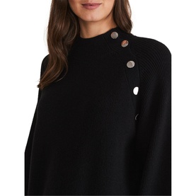 Model wearing Phase Eight Reeva Cosy Button Detail Dress in black, showing high neck and gold button shoulder detail