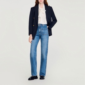 Model wearing Sandro Patch Pocket Straight Leg Jeans in blue jean with navy blazer and white blouse. High-rise, straight fit with patch pockets.