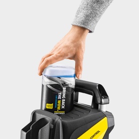 Karcher 3 In 1 Car Shampoo 1L being inserted into a black and yellow pressure washer accessory compartment