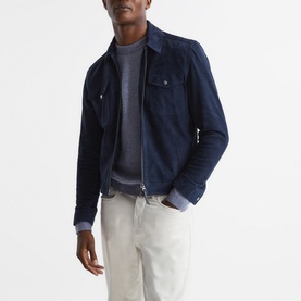 Model wearing Reiss Marcus Blue Crew Ribbed Sweater, styled with a navy zip-up suede jacket and white trousers