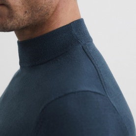 Model wearing Reiss Kelby Turtleneck Sweater in blue wool, close-up detail of ribbed turtleneck collar and knit structure