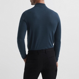 Model wearing Reiss Kelby Turtleneck Sweater in blue, back view, styled with black trousers