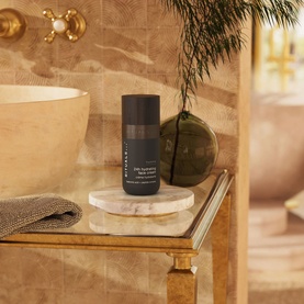 Rituals Homme 24h Hydrating Face Cream dark cylindrical tube displayed on marble tray in luxury bathroom setting