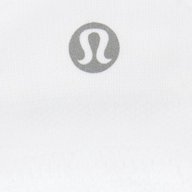 Lululemon Power Stride Tab Socks in white, close-up of grey circular logo detail on fabric