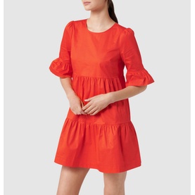Model wearing Forever New Matilda Cotton Smock Dress in red with frill cuffs, round neck, and tiered skirt hem