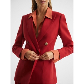 Model wearing Reiss Lola Double Breasted Blazer in red, gold buttons, peaked lapel, styled with orange collared shirt underneath