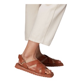 Model wearing Whistles Ren Woven Sandals in brown leather with criss-cross straps, ankle buckle, and flat EVA sole, styled with cream trousers