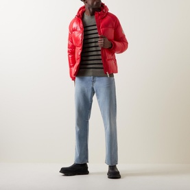Model wearing Pyrenex Sten Puffer Jacket in red, hooded, with striped knit, light blue jeans and black boots