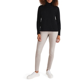 Model wearing Phase Eight Amina Jeggings in brown with exposed side zip, styled with a black roll-neck jumper and white trainers