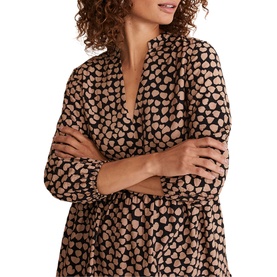 Model wearing Phase Eight Kesia Hearts Swing Dress in cream, featuring V-neck, bracelet sleeves, and allover heart print