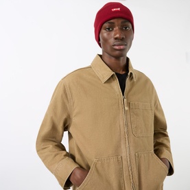 Model with Levi's Batwing Logo Slouchy Beanie Hat in wine, knitted with turned-up brim, styled with a tan zip-up jacket