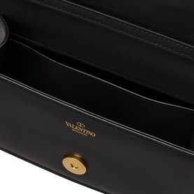 Valentino V Logo Chain Small Shoulder Bag in black leather, interior view showing gold-tone logo stamp and magnetic press-stud fastening