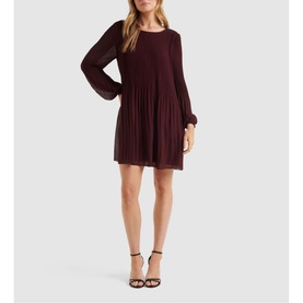 Model wearing Forever New Anna Pleat Mini Dress in green, featuring pleated bodice, blouson sleeves, and round neckline, styled with strappy heels