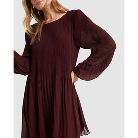 Model wearing Forever New Anna Pleat Mini Dress in green, featuring pleated blouson sleeves, round neckline, and tiered pleated skirt