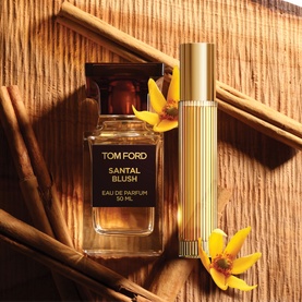 Tom Ford Santal Blush Eau de Parfum 50ml bottle and gold travel spray, styled with cinnamon sticks and yellow flowers