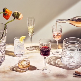 Waterford Aran Mastercraft Clear Crystal Ice Bucket styled with matching cut crystal glasses, wine glasses, and champagne flute on a marble surface