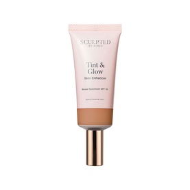 Sculpted by Aimee Tint & Glow Skin Enhancer tinted moisturiser in deep tan shade, tube with gold cap, SPF 15