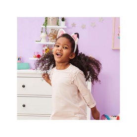 Child wearing Gabbys Dollhouse Magical Musical Ears light-up headband with cat ears, paired with a pink dress, in a purple bedroom setting