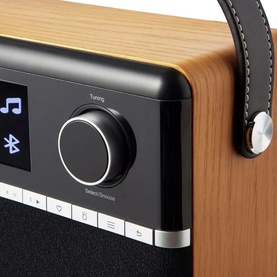 Roberts Stream 94L Wood Internet Radio in brown, close-up showing tuning dial, Bluetooth symbol, and stitched leather handle detail