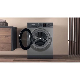 Hotpoint 8kg Freestanding Washing Machine in graphite grey, door open, displayed in a styled laundry room setting
