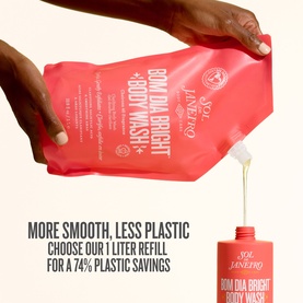 Sol De Janeiro Bom Dia Bright Body Wash 1 litre coral refill pouch held by model's hand, pouring into bottle below