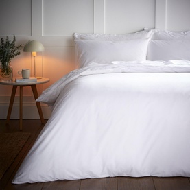 Bianca 200 Thread Count Cooling Tencel Duvet Set in white, styled on a double bed with matching pillowcases, beside a lamp-lit bedside table