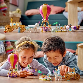 Lego Disney Princess Enchanted Journey set with two children playing, featuring hot air balloon, horse-drawn carriage, and princess figures