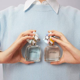 Marc Jacobs Perfect Eau de Toilette 100ml duo held by model, clear glass bottles with decorative charm caps