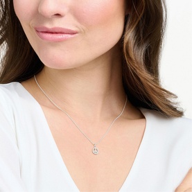 Model with Thomas Sabo Charming Peace Necklace in sterling silver, peace symbol pendant with white zirconia stones, on delicate chain
