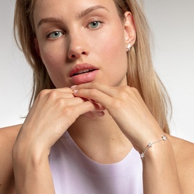 Model with Thomas Sabo Silver Stars Bracelet in sterling silver, slim chain with white zirconia star charms, worn with matching star stud earrings