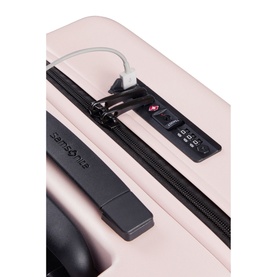 Samsonite STACKD Four-Wheel Expandable Spinner 55cm in pink, close-up showing TSA combination lock and USB charging port detail