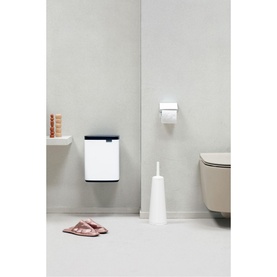 Brabantia Bo Waste Bin 7L in White, wall-mounted in a bathroom setting, shown alongside a toilet brush and toilet roll holder