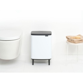 Brabantia Bo Waste Bin Hi 12L in white with dark grey lid and feet, styled in a modern bathroom with toilet and folded towels