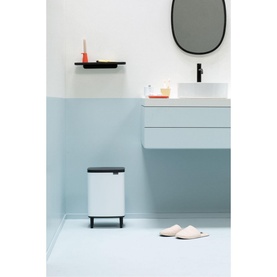 Brabantia Bo Waste Bin Hi 12L in White with black lid, styled in a light blue bathroom setting with sink and accessories