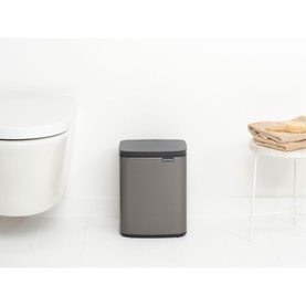 Brabantia Bo Waste Bin 7L in Platinum, rectangular with soft-close dark lid, placed on bathroom floor beside wall-hung toilet