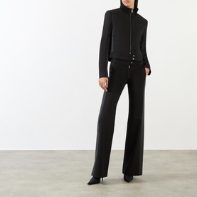 Model wearing Diesel Gauri Short Wool-Blend Zip-Through Jacket in black, styled with wide-leg black trousers and black heels