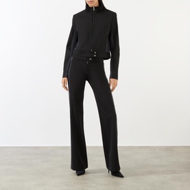 Model wearing Diesel Gauri Short Wool-Blend Zip-Through Jacket in black with matching black flared trousers and heels