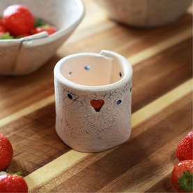Sarah McKenna Home Comforts Tealight Holder, white ceramic with red heart motif and blue dot details, styled on wood surface with strawberries