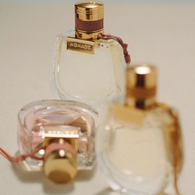 Chlo&eacute; Nomade Jasmin Naturel Intense Eau de Parfum 75ml, clear glass bottle with gold cap, styled with two smaller fragrance bottles