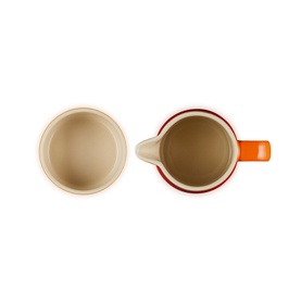 Le Creuset Stoneware Milk & Sugar Set in orange, shown from above displaying interior of sugar bowl and milk jug with handle