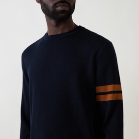 Model wearing Zegna Wool Stripe Sleeve Sweater in navy with tan double stripe detail on sleeve, crew neck, and ribbed trims