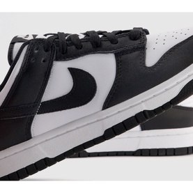 Nike Dunk Low-Top Trainers in white and black leather, featuring black Swoosh logo, perforated toe box, and white rubber track sole