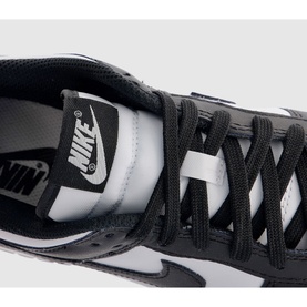 Nike Dunk Low-Top Trainers in white and black, showing close-up of Swoosh logo, lace-up fastening and perforated leather upper detail