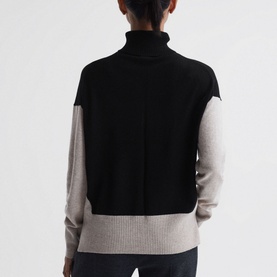 Model wearing Reiss Alexis Colour-Block Sweater in beige and black, roll-neck, dropped shoulders, rib-knit hem, rear view